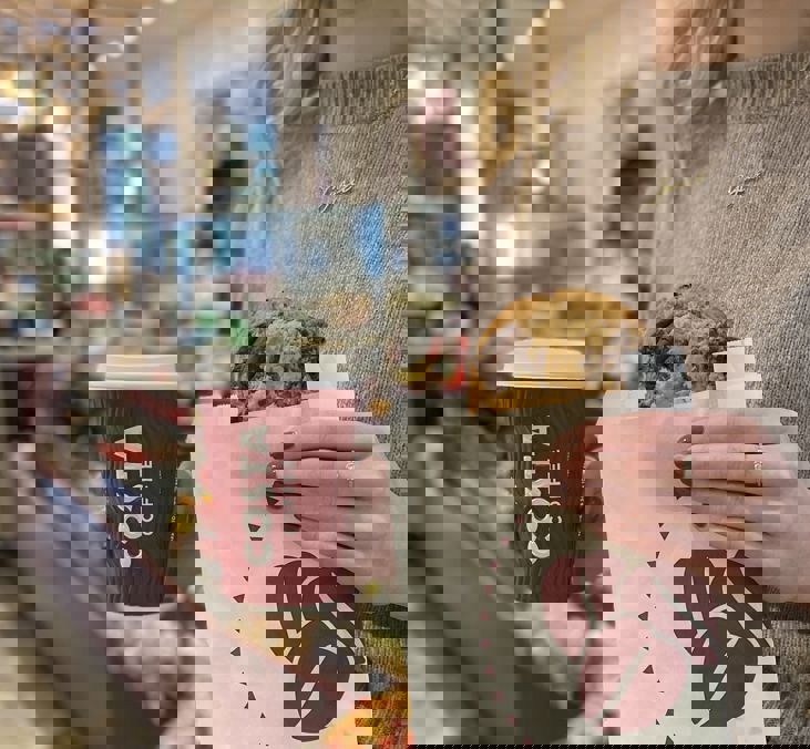 One Costa Woman Holding Coffee And Belgian Cookie Square